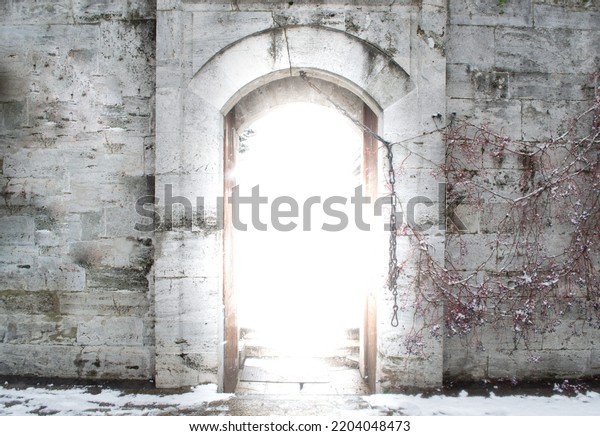 Light from behind door of fortress wall, life\
after death concept, eternal life idea, religious heaven award\
\