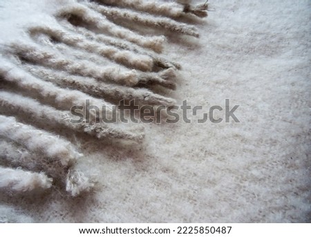 Light beige wool fabric texture. Cozy scarf for keeping warm in cool weather, winter and christmas season background. Copyspace. Selective focus.