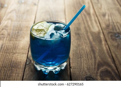 light blue alcoholic drink curacao liqueur on wooden background