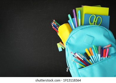 Light blue backpack with different stationery on blackboard, top view and space for text. Back to school