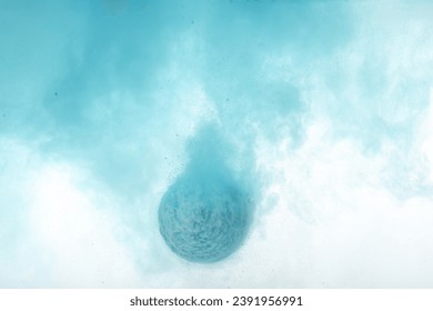 Light blue bath bomb dissolving in water