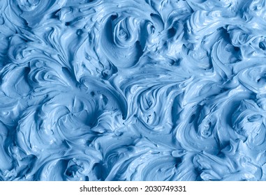 Light blue bentonite facial clay (alginate mask, face cream, body wrap) texture close up, selective focus. Abstract background with swirl brush strokes. 