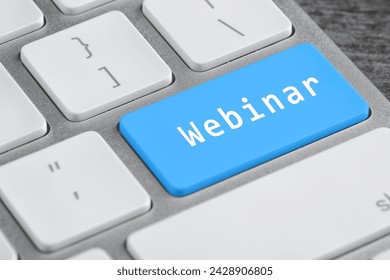 Light blue button with word Webinar on computer keyboard, closeup