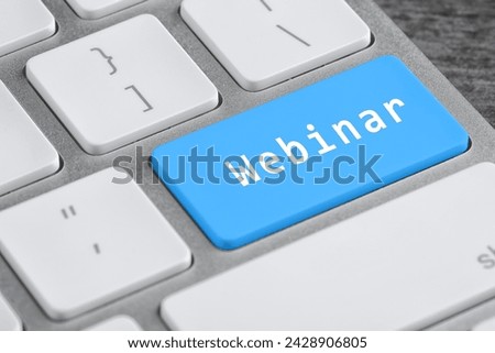 Light blue button with word Webinar on computer keyboard, closeup