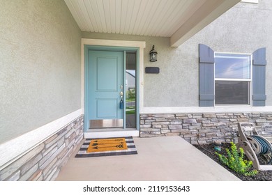 Light Blue Front Door With Lockbox And Doormat On A Concrete Entrance