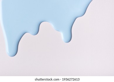Light blue liquid drops of paint color flow down on isolated white background. Abstract sky backdrop with fluid drip pattern. Acrylic painting with copy space.