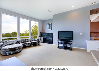 Light Blue Living Room Interior With Tv, Fireplace And White And Black Couch