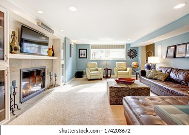 Light Blue Living Room With Leather Furniture Set, Beige Carpet Floor, Tv And Fireplace