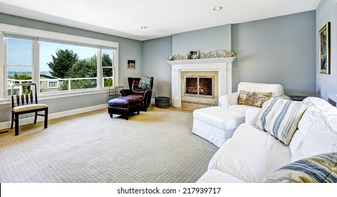 Light Blue Living Room With White Sofa, Armchair And Leather Chair And Cozy Fireplace