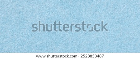 Light blue matte background of suede fabric, closeup. Velvet texture of seamless sky woolen felt.