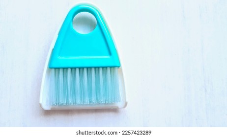 Light blue mini broom and dust pan isolated on white background, a table cleaning brush, car vent air blind keyboard cleaner  - Shutterstock ID 2257423289