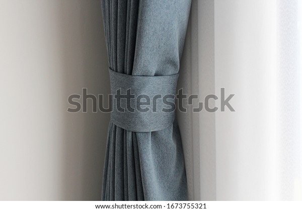 Light blue mix
with grey curtain tie back or curtain straps tied the curtain with
the white sheer background. Soft and smooth  mood with copy space.
Curtains are in ling
room.