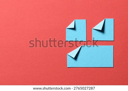 Light blue paper message notes or sheets with folded edge dog-ear earmark and copy space for text on red background, top view flat lay conceptual desk backdrop