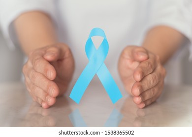 Light blue ribbon awareness in hand for Prostate cancer , lymphedema ,Men's Health in November. 