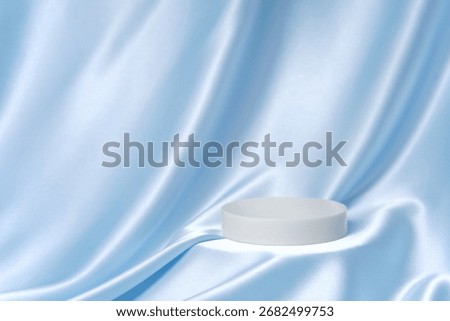 Light blue satin drape with a single round podium and generous copy space. Minimal luxury background for cosmetics, skincare and packaging ads.
