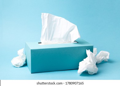 Light blue tissue box and crumpled tissues on blue background. Cold and flu concept. Minimal monochromatic composition. - Shutterstock ID 1780907165