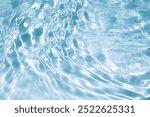 light Blue water with ripples on the surface. Defocus blurred transparent clear calm water surface texture with splashes and bubbles. Water waves with shining pattern texture background.