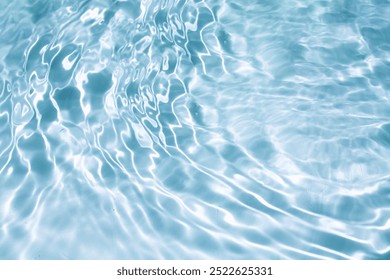 light Blue water with ripples on the surface. Defocus blurred transparent clear calm water surface texture with splashes and bubbles. Water waves with shining pattern texture background.