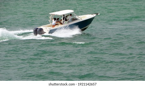 Light blue and white motor boat powered by two outboard engines speeding on the Florida Intra-Coastal Waterway .
