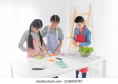 Light And Blur People,  Asian Children Cooking Organic Salad N Kitchen Room, They Use Knife Slice Fresh Vegetable, Happiness Cooking Education