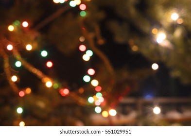 Light Blurred Multicolored Lights On A Real Christmas Tree Outside In The Snow. Bokeh.