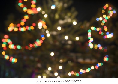 Light Blurred Multicolored Lights On A Real Christmas Tree Outside In The Snow. Bokeh.