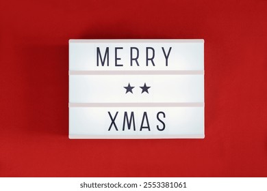 Light box with merry xmas text over red background. - Powered by Shutterstock