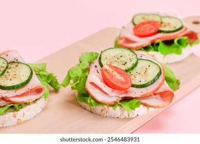 Light Breakfast. Quick and Healthy Sandwiches. Rice Cakes with Ham, Tomato, Fresh Cucumber and Green Salad on Wooden Cutting Board - Powered by Shutterstock