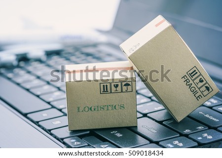 Light brown cardboard boxes on a laptop keyboard. An idea of transportation that can be done easily nowadays using an online internet at hand. Shipping / freight forwarding business concept.