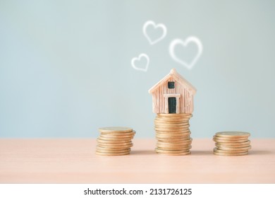 Light Brown House Model On Top Stack Of Coin And Blurred Heart   For Business Investment ,real Estate Loan, Warm Family, Healthy And Wealthy  Concept