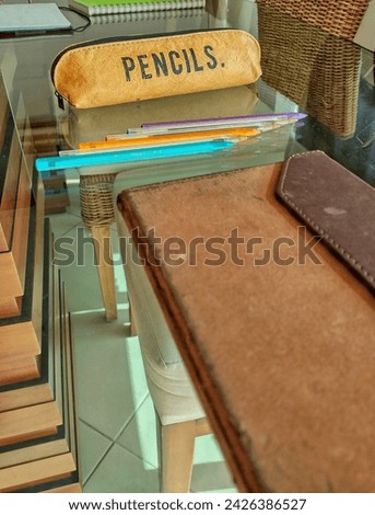 A light brown pencil case with a sign that says 