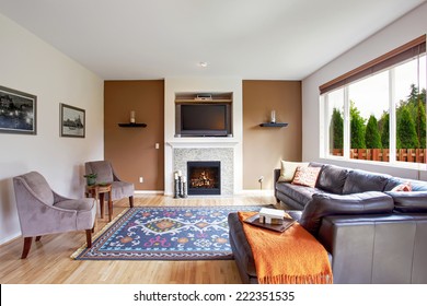 Light Brown Tone Living Room With Fireplace And Tv. Comfort Leather Couch With Pillows And Orange Blanket