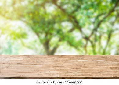 Light Brown Wood Table On Blurred Public Garden Background With Sunlight