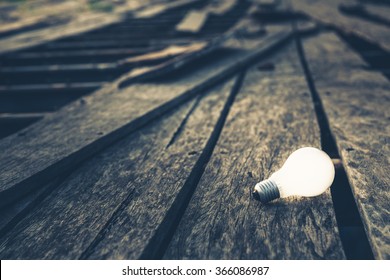 Light bulb glowing on broken wood bridge