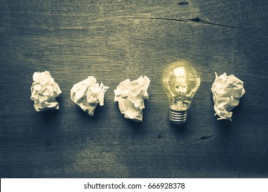Light bulb glowing in a row of crumpled ball paper, learning from mistake - Shutterstock ID 666928378