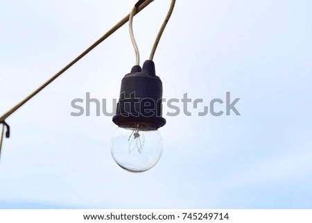 Light bulb hanging with rope on the beach.