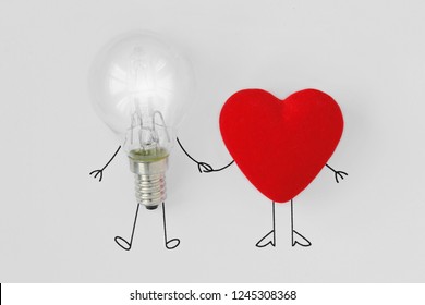 Light bulb and heart holding hands - Concept of brain and heart teamwork
