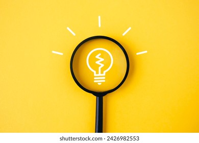 Light bulb and idea checking icon inside magnifier glass on yellow background. Creativity and new innovation with energy and power