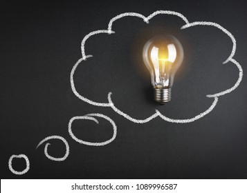 Light Bulb Inside Of Chalk Handwritten Cloud. Idea Concept 