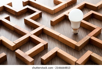 Light bulb in the maze game built by wood blocks, finding the right way to the success, searching creative idea concept - Shutterstock ID 2146664813