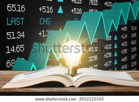 Light bulb and opened the vintage book. Stock market or forex trading graph