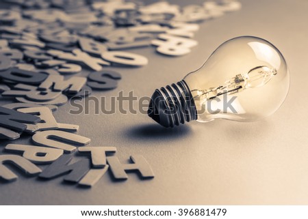 Light bulb and scattered wood letters