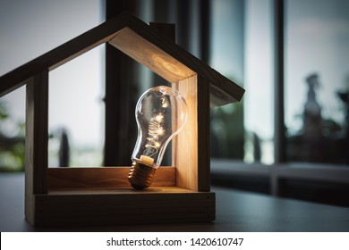 Light bulb with wood house on the table, a symbol for construction, Creative light bulb idea, power energy or business idea concept ecology, loan, mortgage, property or home. - Shutterstock ID 1420610747