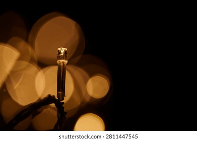 Light bulbs glowing against backdrop of golden bokeh