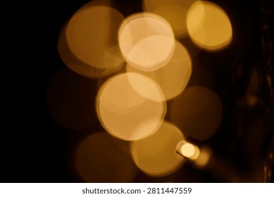 Light bulbs glowing against backdrop of golden bokeh