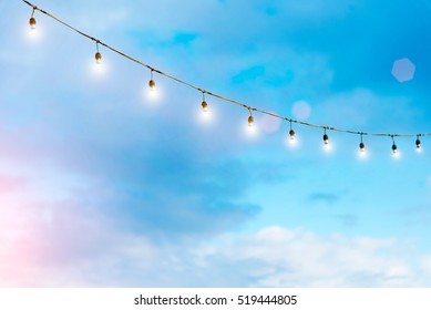 Light Bulbs On String Wire Against The Sky. Party Light. Good Life Or Success Concept.
