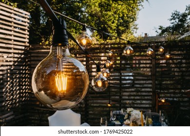 Light bulbs outdoors at a party in evening time.