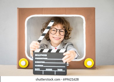 Light, Camera, Action! Child Playing With Cardboard Box TV. Kid Having Fun At Home. Video Blogging Concept