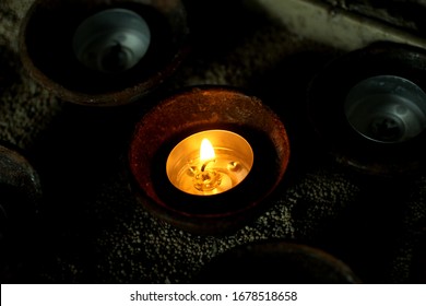 Light Of A Candle. One Burning Candle And The Other Candles Is No Longer Able To Ignite. Single Candle Lights Up On Natural Ceramic Bowl In The Dark. Be The Light Concept.