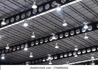 light ceiling and nature sunlight in warehouse. light bulb of exhibition hall hang under the metal roof. airy interior design of gym and stadium.  bright office industrial construction building.